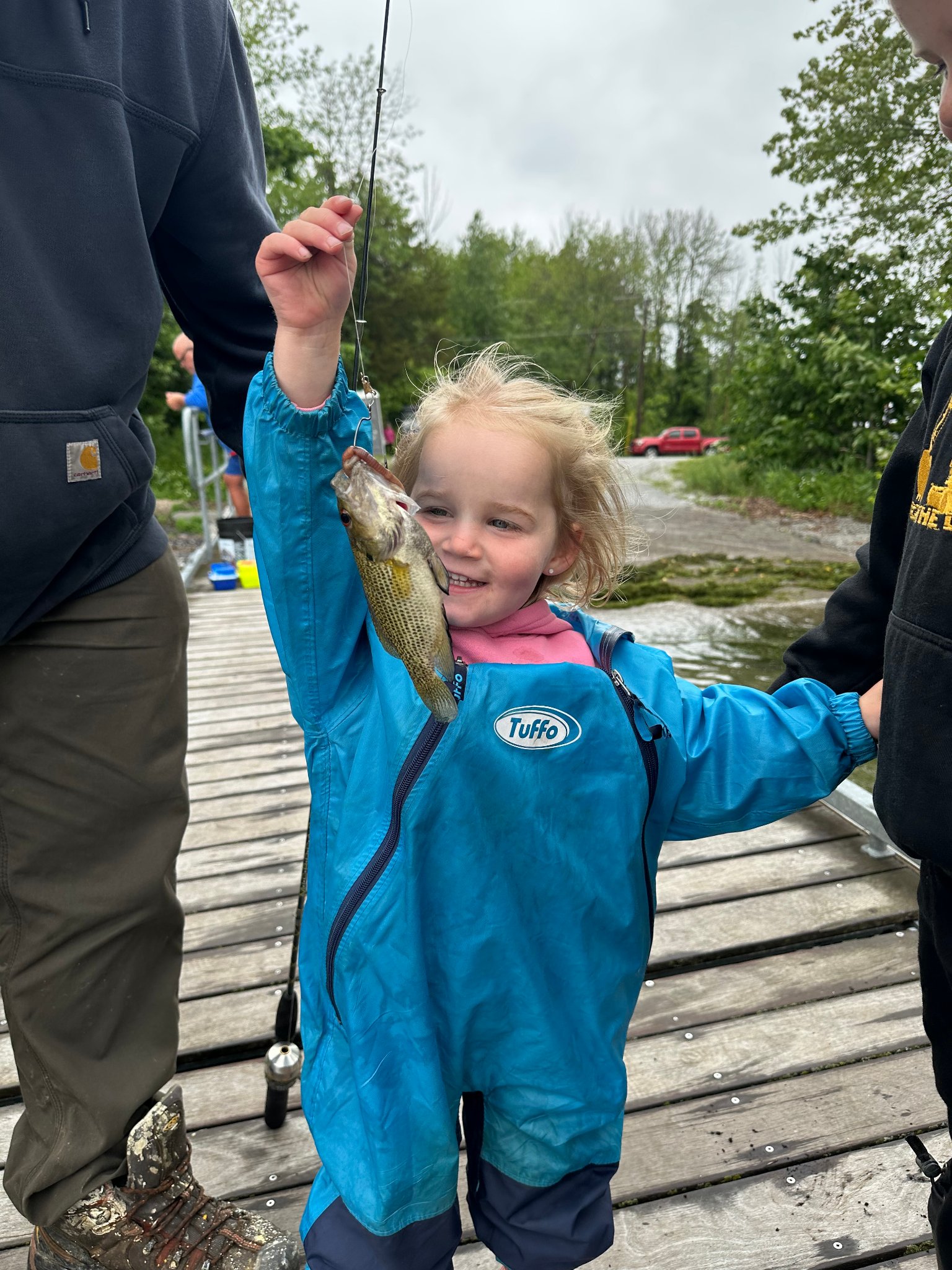 Young girl proudly holding a fish she caught